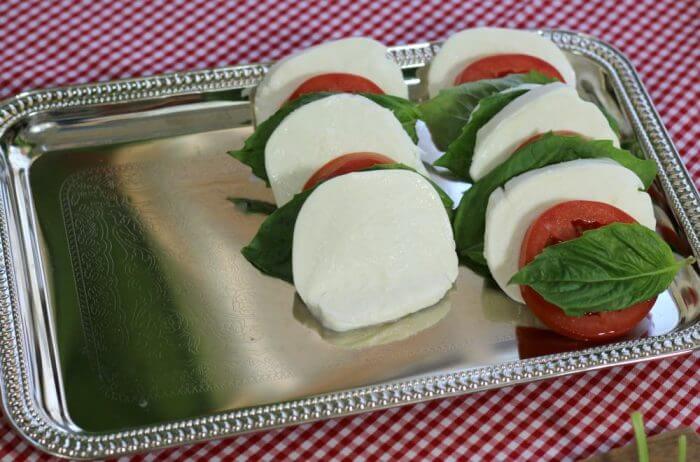 layer the ingredients for tomato mozzarella caprese salad