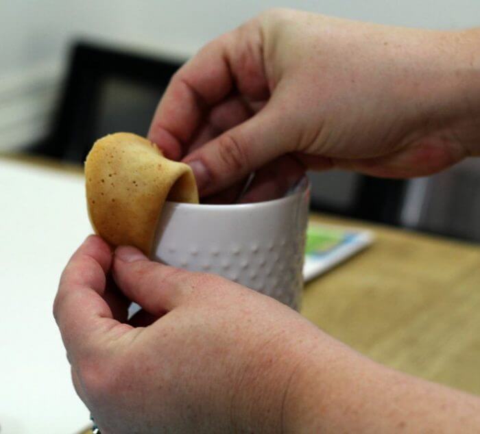 Continue folding over the edge of the cup until the cookie is the desired shape.
