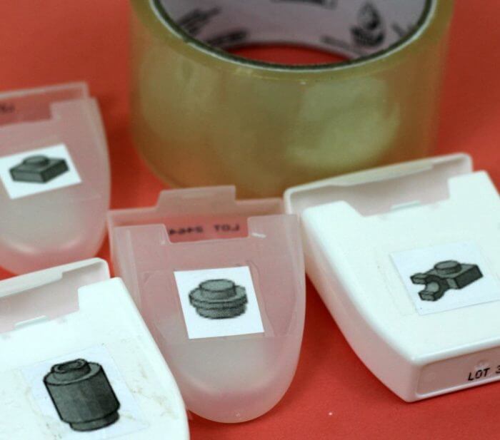 Tape the Lego labels onto the containers with clear tape