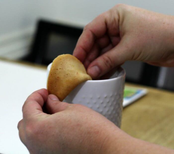 Use the edge of a cup to fold over the fortune cookie.