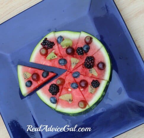 Use a pizza slicer to cut the watermelon fruit pizza into slices