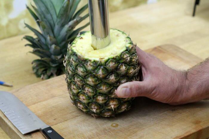 Keep turning the corer to continue cutting through the pineapple