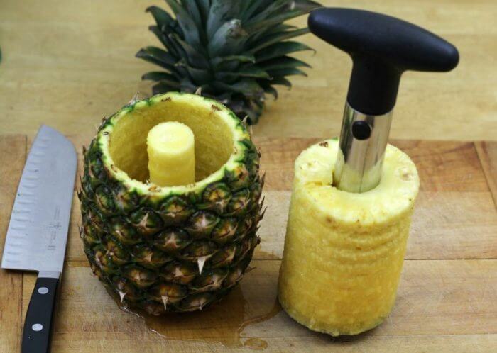 Pull the corer and the center out of the pineapple