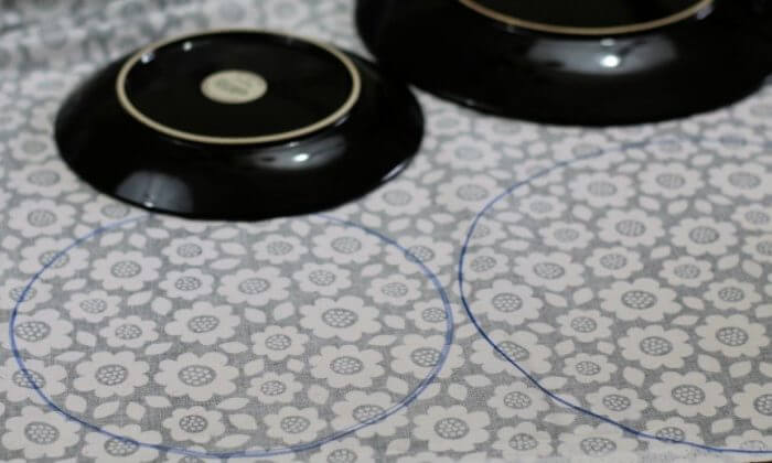 Trace circles on the back of the laminate fabric. You need two circles for each cover you want to make.