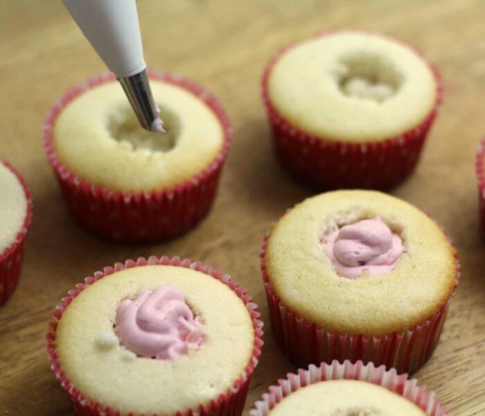 Fill a pastry bag with the strawberry mousse and fill the cupcakes